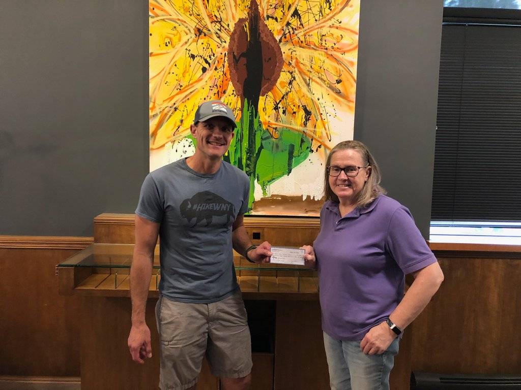 BRRAlliance Executive Director Anne McCooey and Outside Chronicles creator Mike Radomski with the proceeds from the 2024 Urban Treks Challenge.